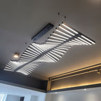 This Clérachic white bar chandelier fans above a dark accent wall, its bars glowing bright and even.
