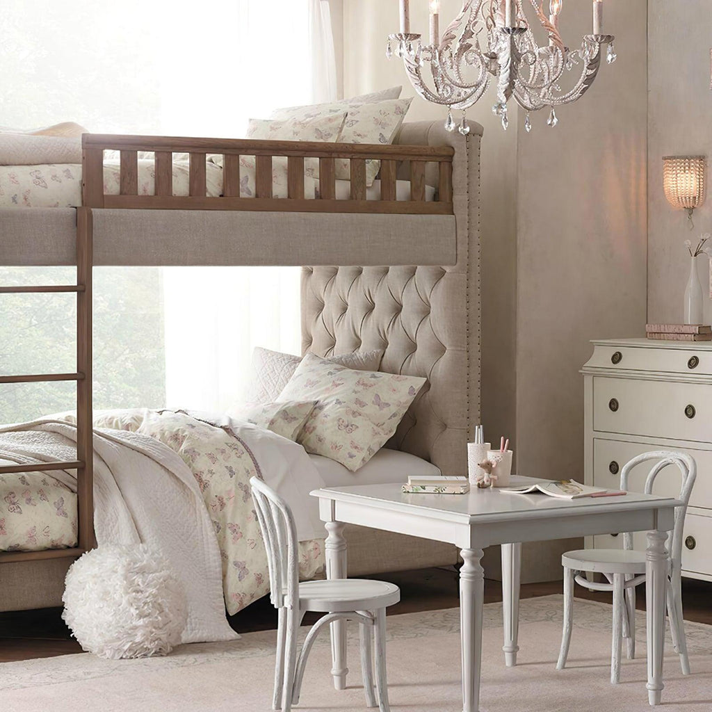 Above a bunk bed and a small white desk, this Clérachic chandelier hangs in a child's bedroom with a floral quilt.