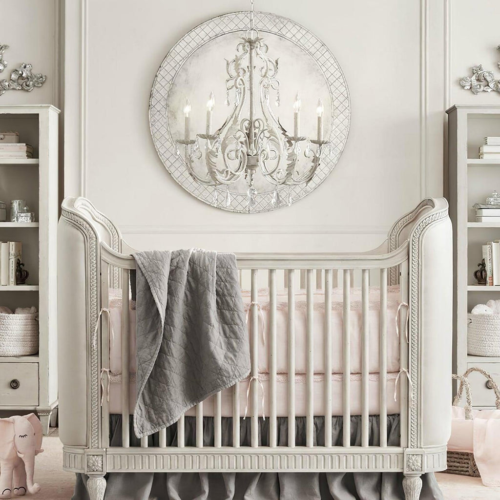 A Clérachic chandelier mounted in front of a round lattice wall panel, above a white cot with a grey throw.