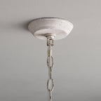 Close view of the round, chalky white ceiling canopy and the first links of the chain on this Clérachic chandelier.