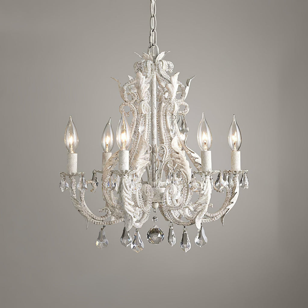 A Clérachic chandelier with ivory candle sleeves and a large centre crystal ball, photographed against a grey wall.