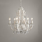 A Clérachic chandelier with ivory candle sleeves and a large centre crystal ball, photographed against a grey wall.
