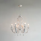 A smaller Clérachic chandelier with white metalwork and a white ceiling cup, lit against a pale grey wall.
