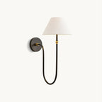 Front view of this Clérachic wall light on a white backdrop, with a white fabric shade on a black U-shaped arm and a round backplate.
