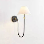This Clérachic wall light in black and white, lit softly, with a curved black arm looping down from a round plate to a tapered shade.