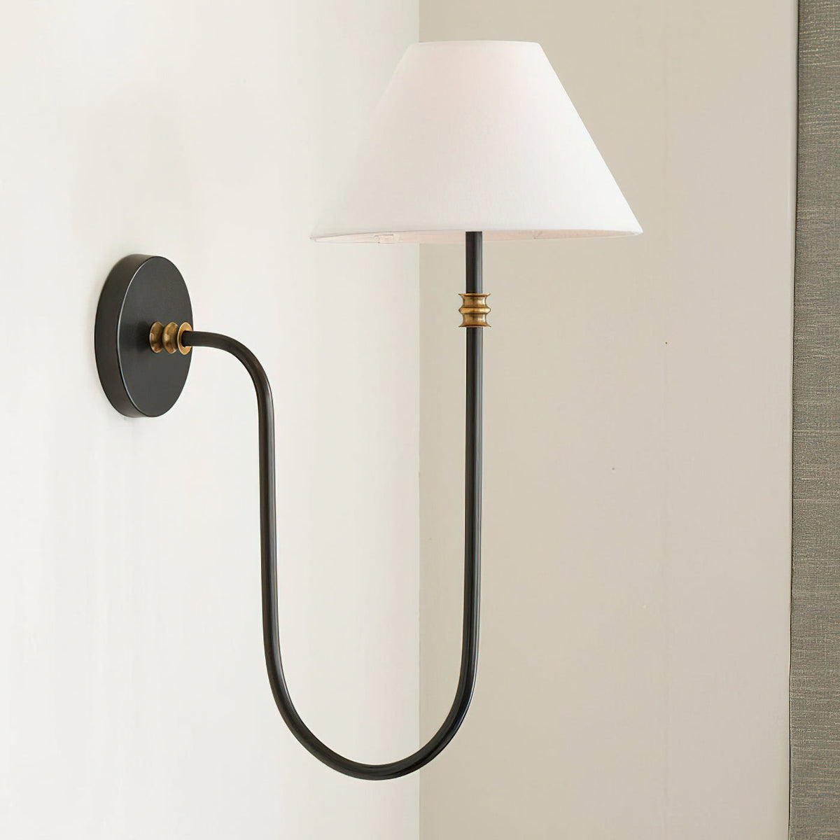 Black Clérachic wall light with a white shade and a deep U-shaped arm, seen from slightly below against a pale wall.