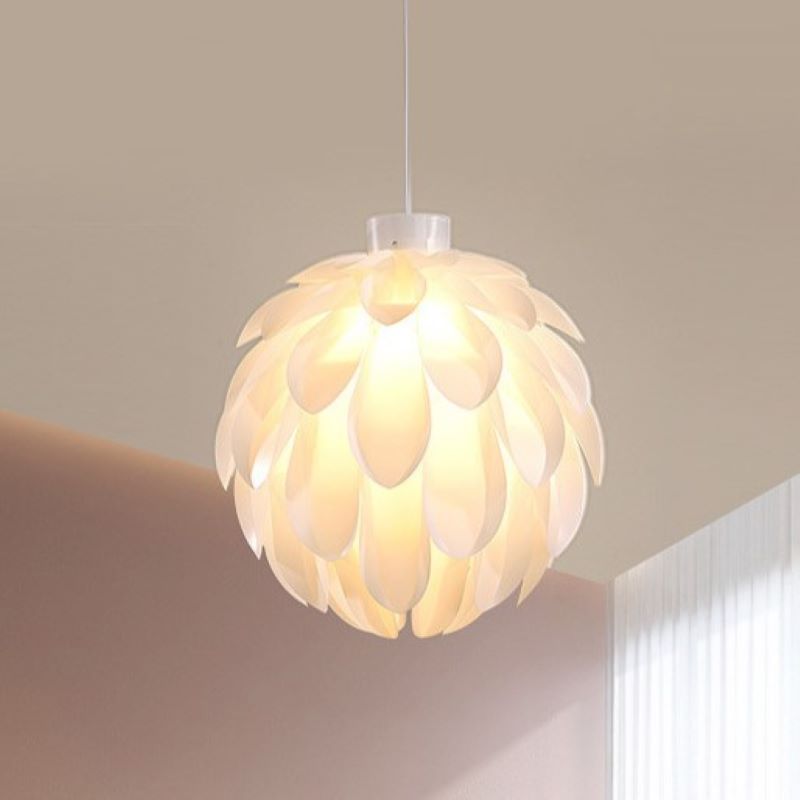 The Clérachic White Flower Pendant Light hangs lit against a beige wall, warm glow through overlapping petals.