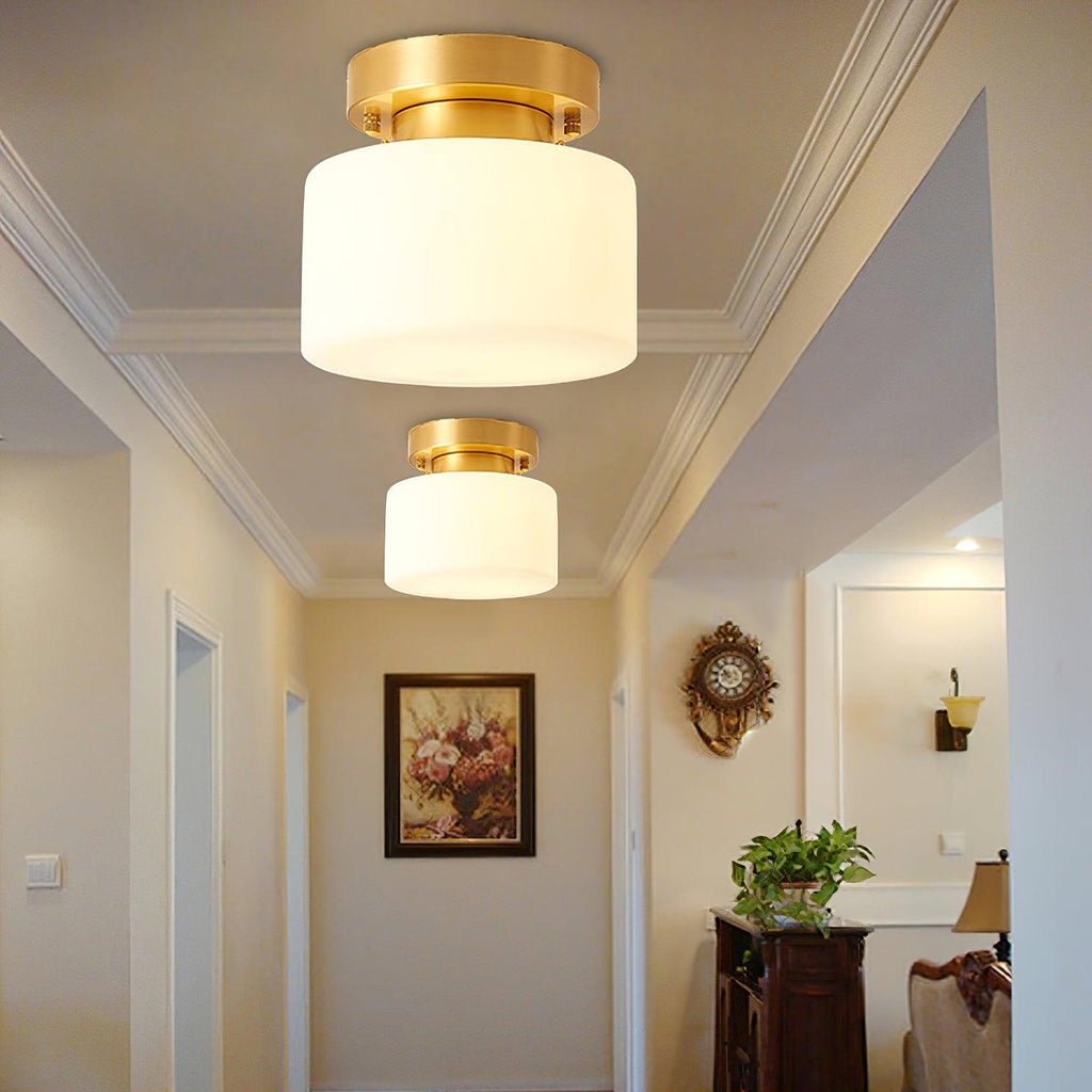 A larger Clérachic flush-mount light in the foreground and a second further down a cream hallway with cornice mouldings and a framed floral print.