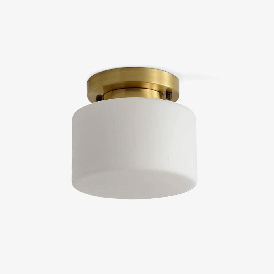 This Clérachic flush-mount ceiling light on a plain off-white backdrop, a white drum glass shade under a round brass canopy.
