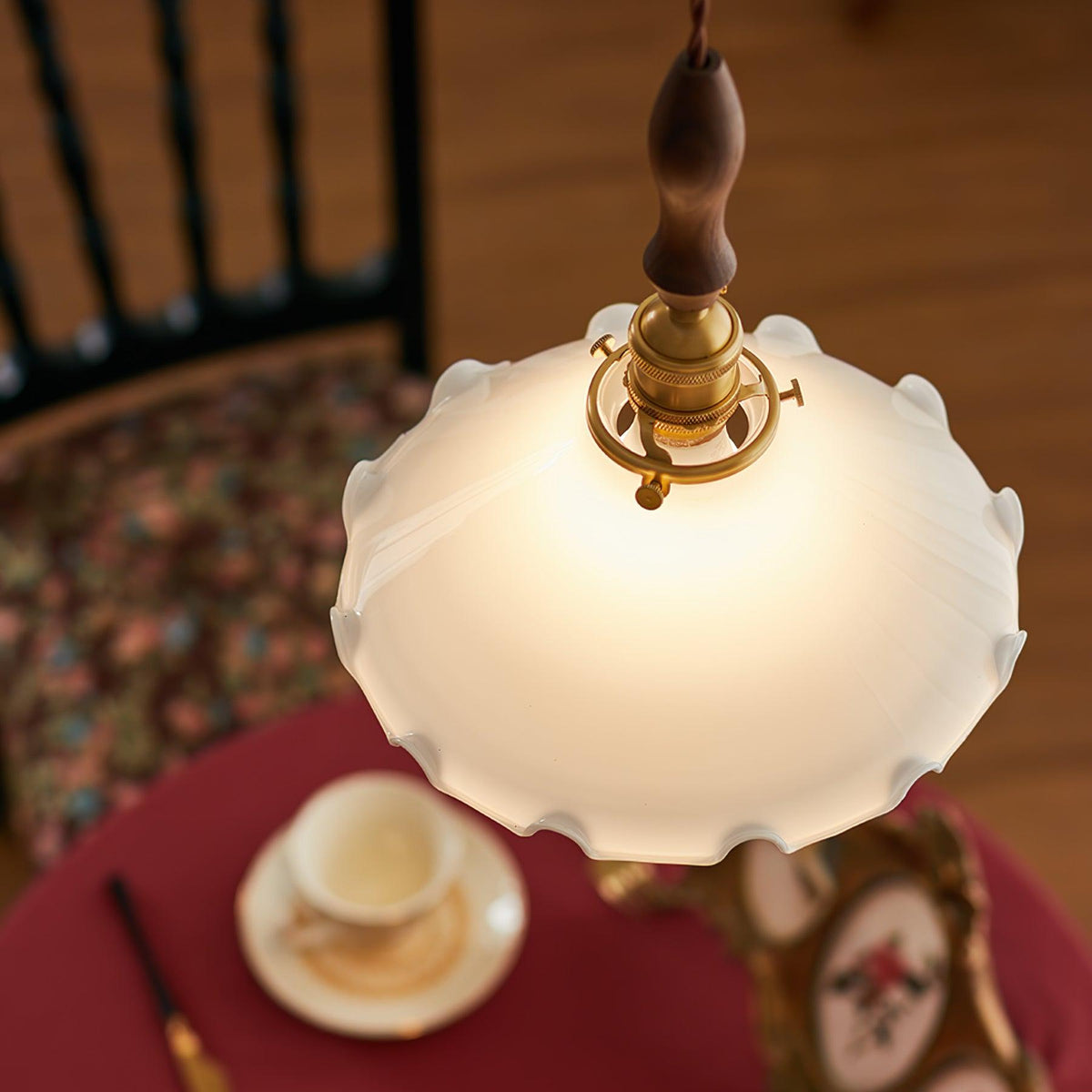 Looking down on the shade of this Clérachic pendant light, with a red-clothed table and a teacup blurred below.