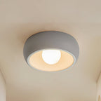 Grey Clérachic ceiling light on a cream ceiling, a rounded grey bowl with a white inner rim and a lit round bulb.