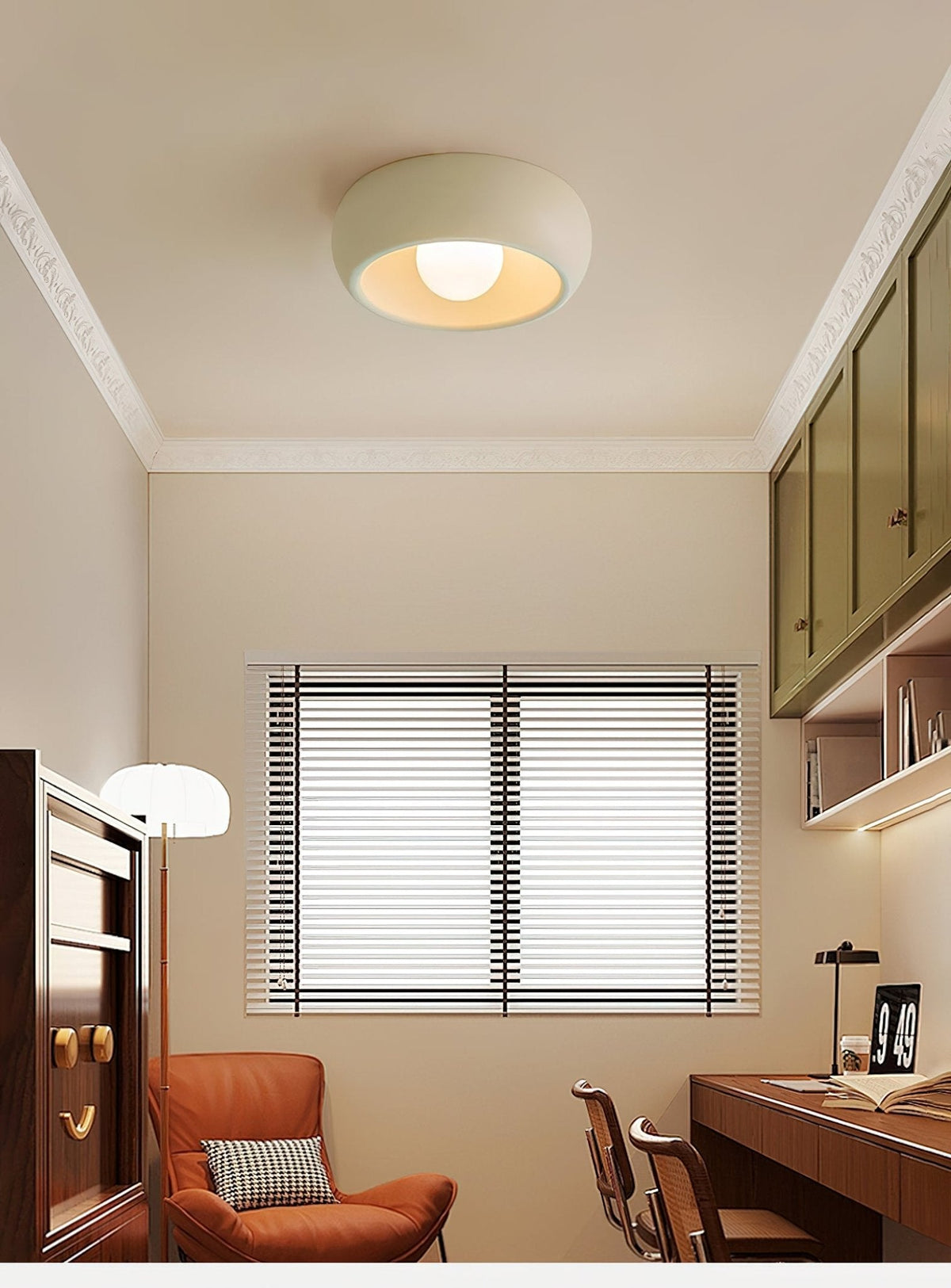 Beige Clérachic ceiling light in a small study with white mouldings, an orange armchair, a desk and green wall cabinets.
