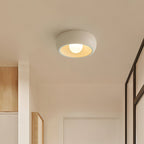 Beige Clérachic ceiling light in a narrow passage with pale wood panelling and a dark-framed glass door at the side.
