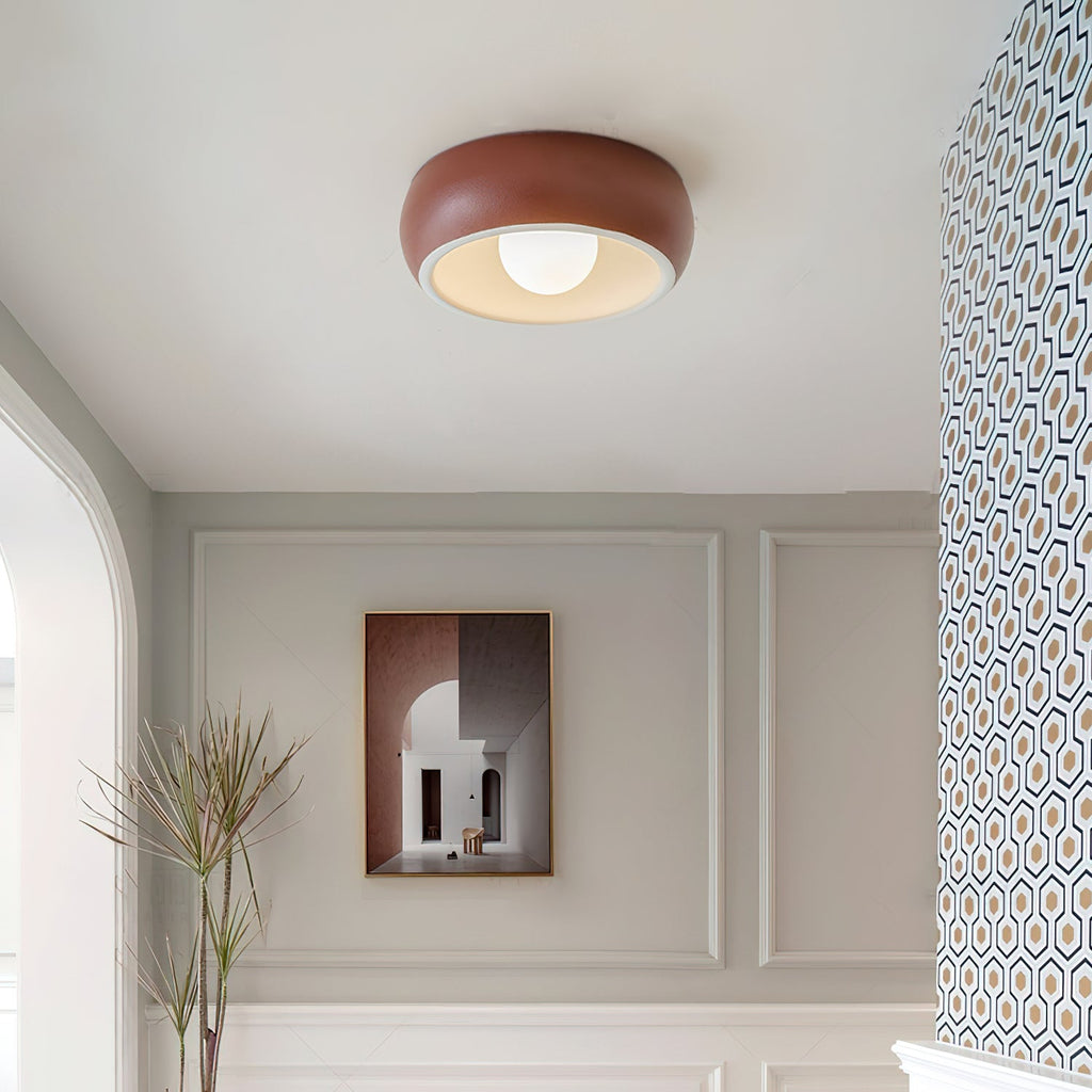 Red Clérachic ceiling light in a grey-panelled entrance with a framed print, a tall grass in a pot and patterned wallpaper.