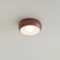 Red Clérachic ceiling light on a pale ceiling, a terracotta-red outer bowl around a white inner rim and a round bulb.