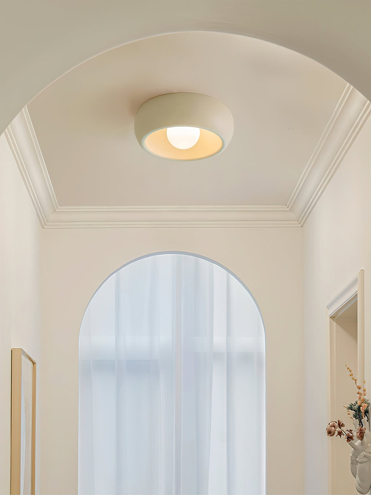 Beige Clérachic ceiling light in an arched hallway with white cornicing and a tall arched window with sheer curtains.