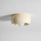 Side view of this beige Clérachic ceiling light, the round bulb just visible below the rim of its shallow bowl.