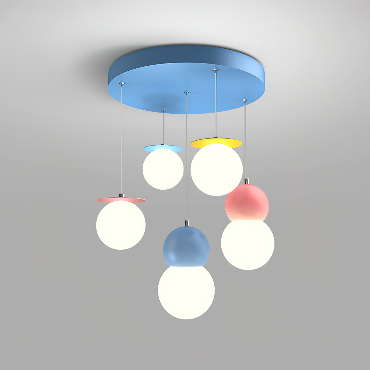 This Clérachic chandelier with a wide round blue canopy and five globes at different heights on thin cords, lit against a grey backdrop.