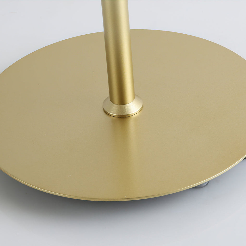 Close view of the flat round gold base and the stem fitting on this Clérachic table lamp.
