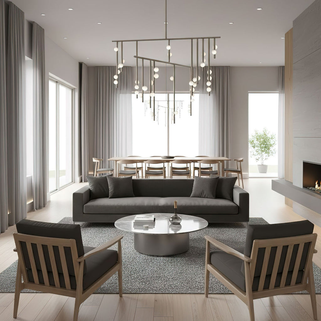 A Clérachic chandelier with brass bars and white orbs over a long dining table in a pale grey open-plan room, with a dark sofa in front.