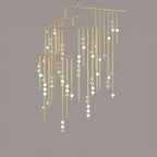 A Clérachic chandelier in brass with many tiers of drop rods and white orbs, on a taupe backdrop.