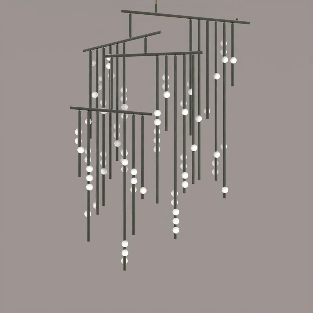 A black Clérachic chandelier with many tiers of drop rods and white orbs, on a taupe backdrop.