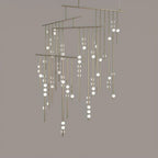 A Clérachic chandelier with many tiers of drop rods in a pale nickel finish, on a taupe backdrop.