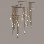 A Clérachic chandelier in antique bronze with many tiers of drop rods and white orbs, on a taupe backdrop.