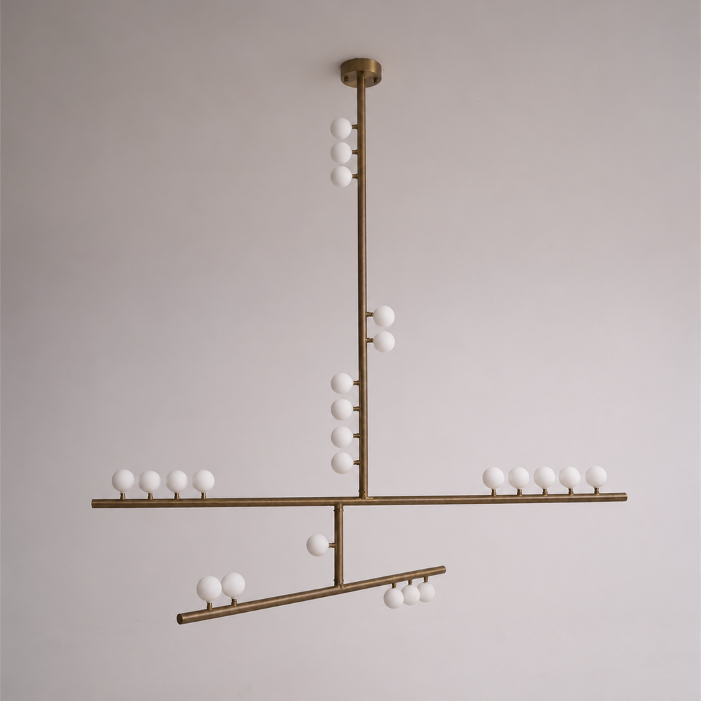 A Clérachic pendant in antique bronze, with a round ceiling plate and crossed bars, on a soft grey wall.