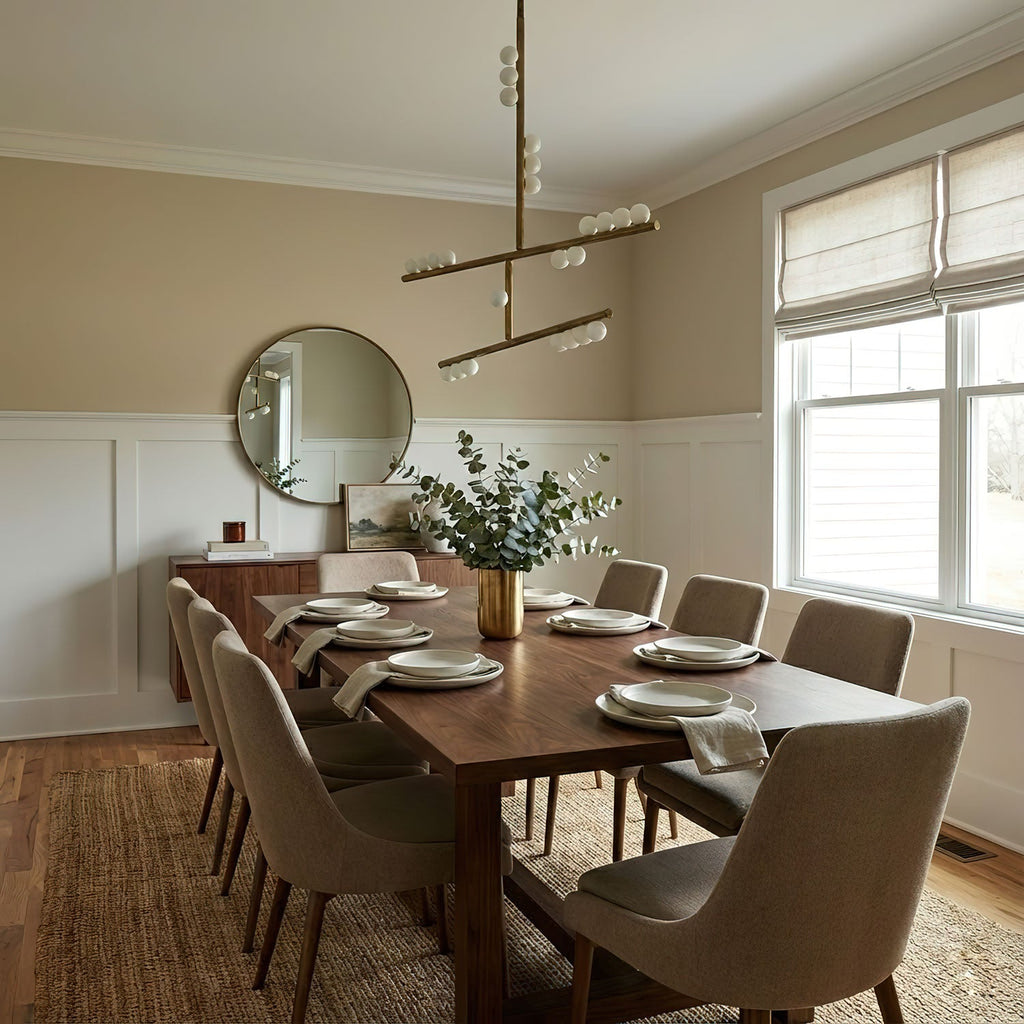 Above a walnut dining table in a beige room, a Clérachic pendant of brass bars carries white glass orbs at staggered heights.