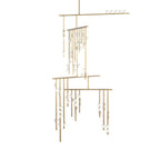 This Clérachic chandelier in brass with white orbs, on a plain white backdrop, with bars stepping down in three tiers.