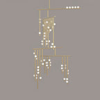 Brass version of this Clérachic chandelier with white orbs, on a flat taupe backdrop.