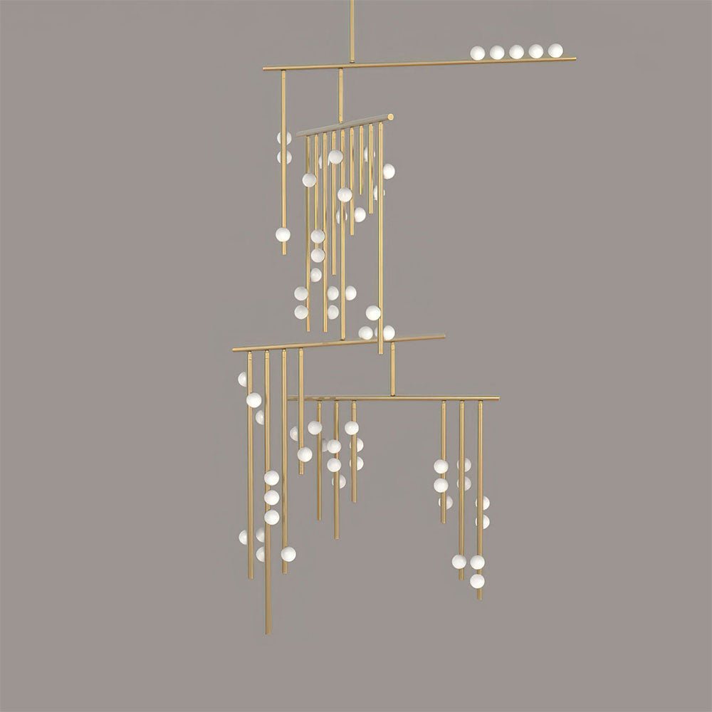 Brass version of this Clérachic chandelier with white orbs, on a flat taupe backdrop.