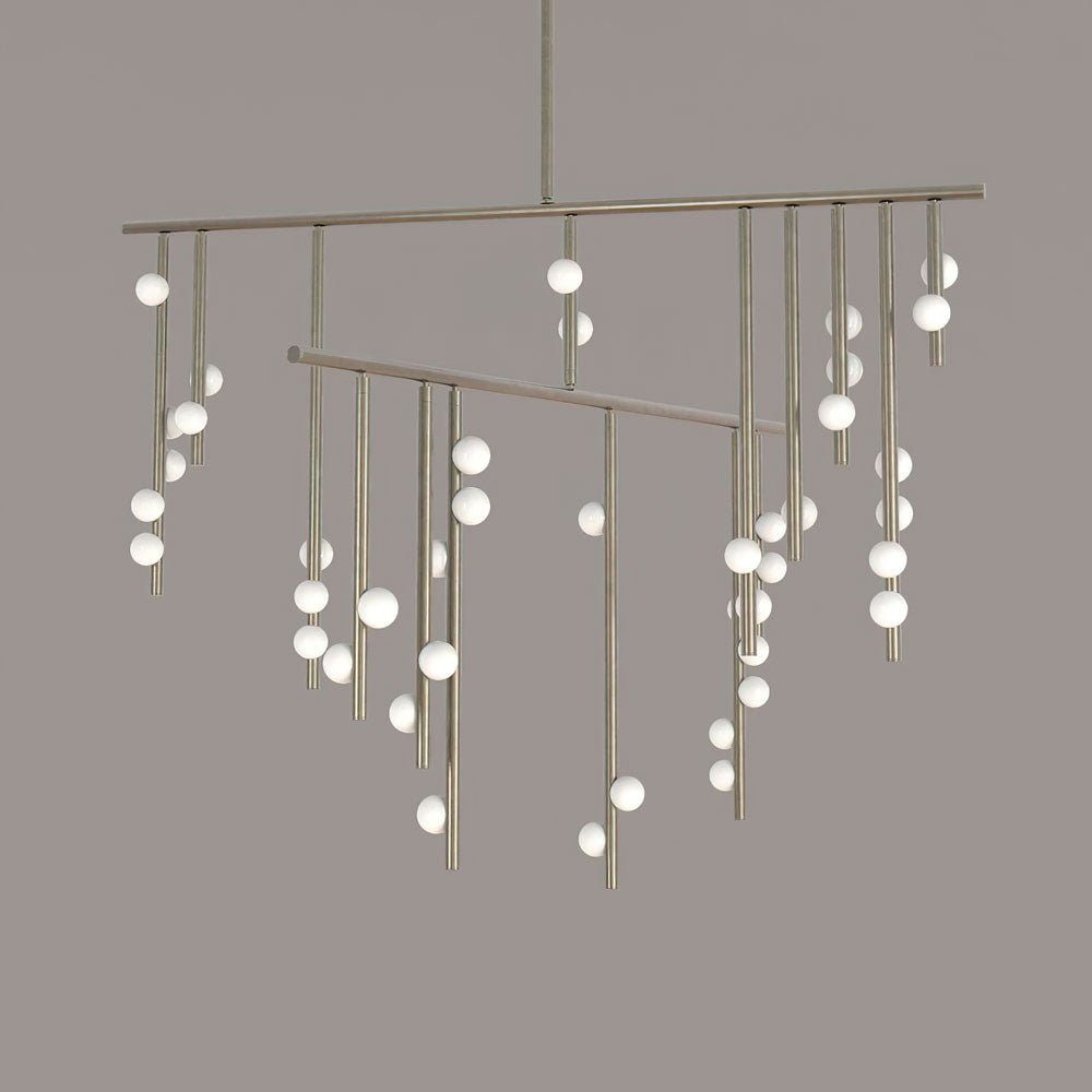 Close view of the long brass rods and scattered white orbs on this Clérachic chandelier, against a taupe backdrop.