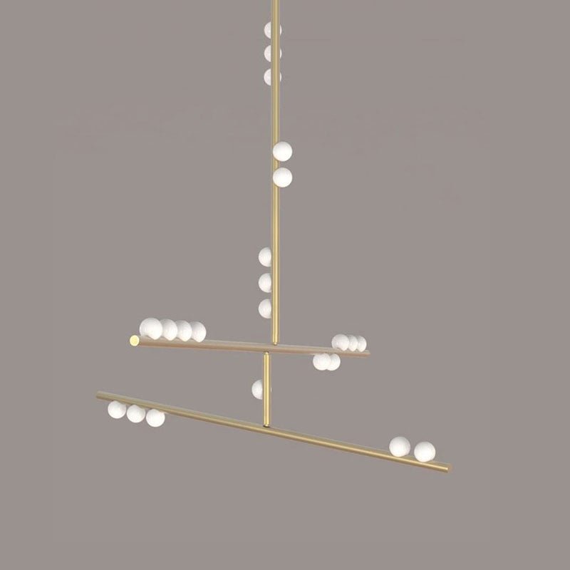 This Clérachic pendant in brass, on a taupe backdrop, with a long rod and two tilted bars carrying white orbs.