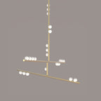This Clérachic pendant in brass, on a taupe backdrop, with a long rod and two tilted bars carrying white orbs.