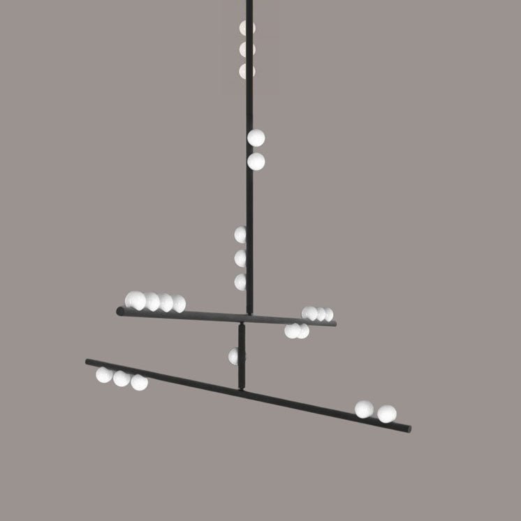 A black Clérachic pendant with two tilted bars and white orbs on a taupe backdrop.