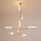 Warm glow from the white orbs on this Clérachic brass pendant, hung against a dusky peach wall.