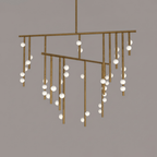 Close view of the antique bronze rods on this Clérachic chandelier, with white orbs scattered along them.