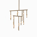 This Clérachic mobile-style chandelier in antique brass, on a white backdrop, with two bars and white orbs on its drop rods.