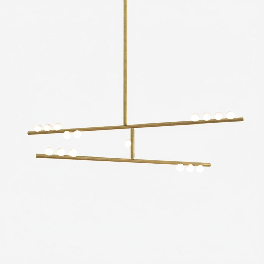 This Clérachic two-bar pendant in brass with white orbs along the bars, on a pale backdrop.