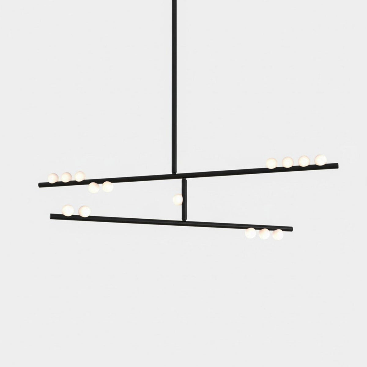 A black Clérachic two-bar pendant with white orbs along each bar, on a pale backdrop.
