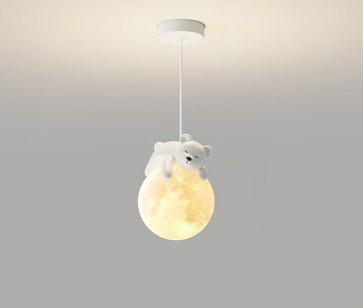 A Clérachic bear pendant hangs from a white round ceiling plate, its glowing globe lit warm against a grey wall.