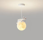 A white rabbit with pink-lined ears sleeps on the glowing globe of this Clérachic pendant, hung from a white ceiling plate.