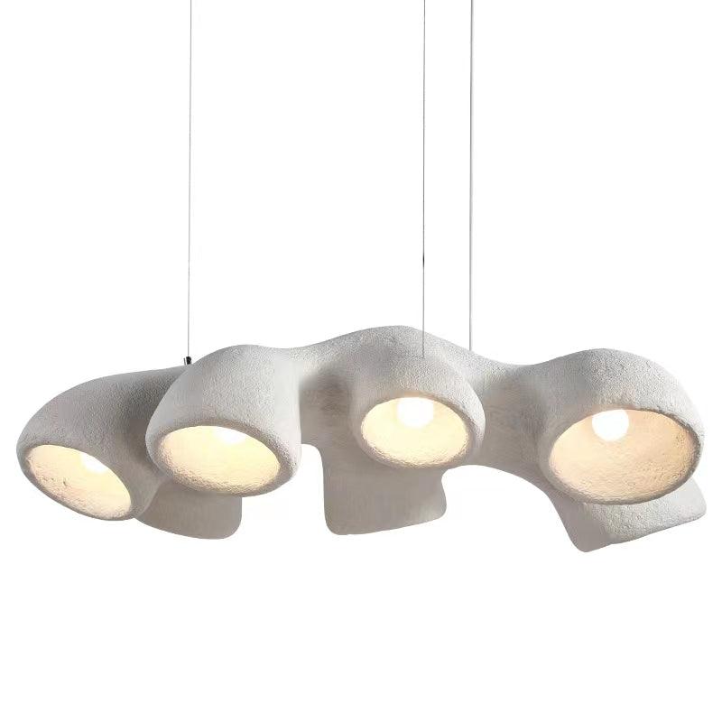 Side view of this Clérachic pendant on white, four white openings in a row, each holding a lit bulb, hung from three cables.