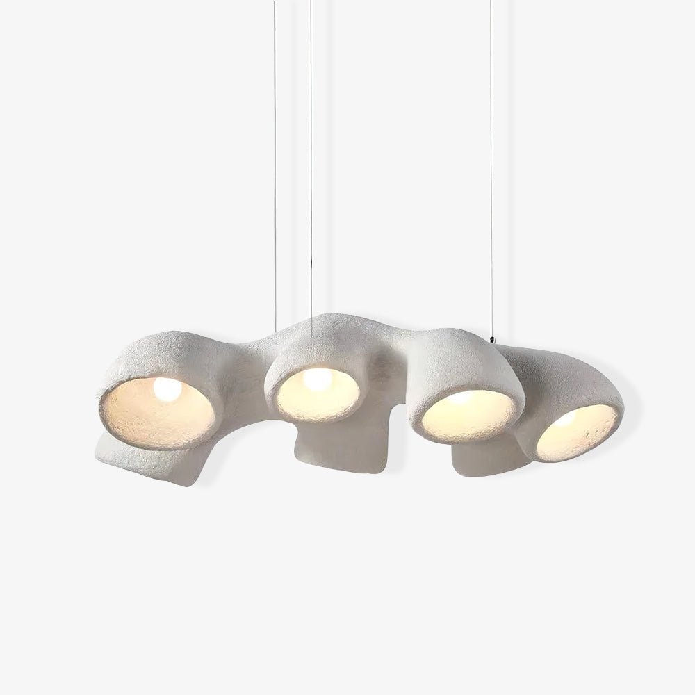 A long four-opening Clérachic pendant on a pale backdrop, hanging from three thin cables with each bulb lit.