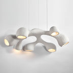 Clérachic pendant seen at an angle, its textured white arms glowing in warm light against a pale grey backdrop.