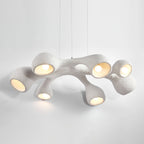 Clérachic pendant on a pale grey backdrop, its branching white arms lit from inside and casting a soft glow below.