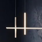 Close-up of the Clérachic pendant light in white, both vertical bars glowing warm against a dark textured wall.