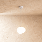 Clérachic glowing white pebble pendant with an uneven rounded shade and a grey metal cap on thin suspension wires